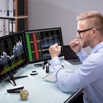 scottrade online stock trading service man happy in front on laptop checking stocks